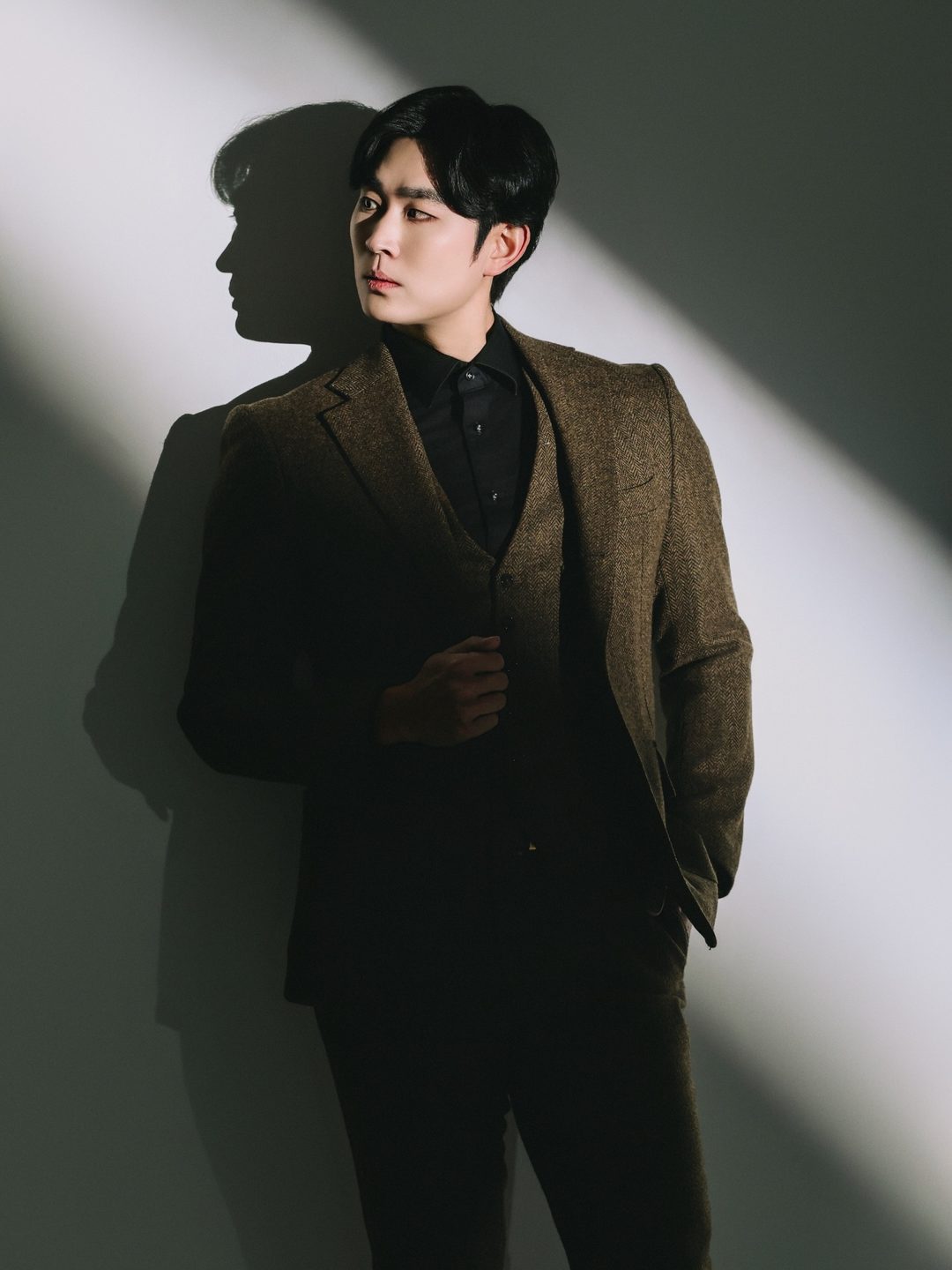 빛줄기 사이에 트위드 재킷 차림으로 선 박기태